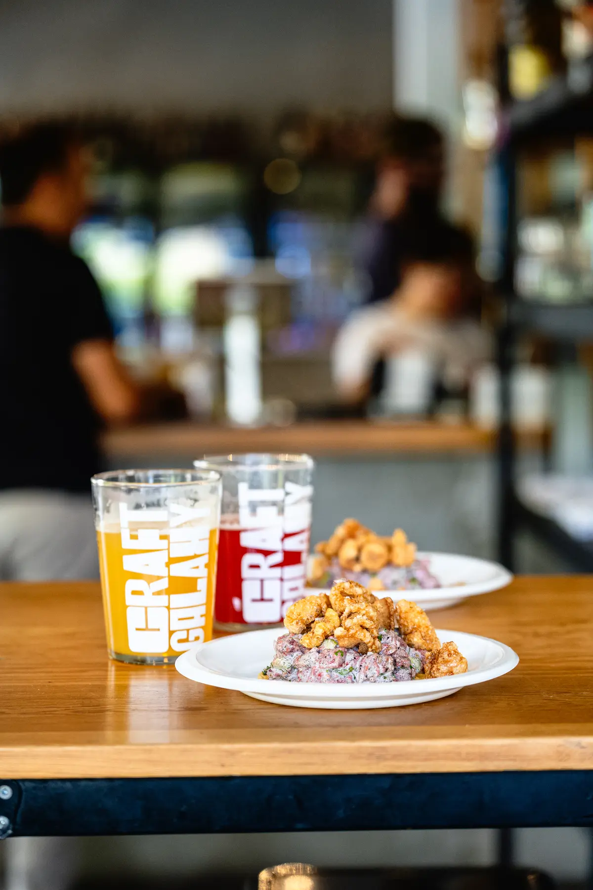 Cervezas y comida compartidas en una mesa de Craft Chapalita